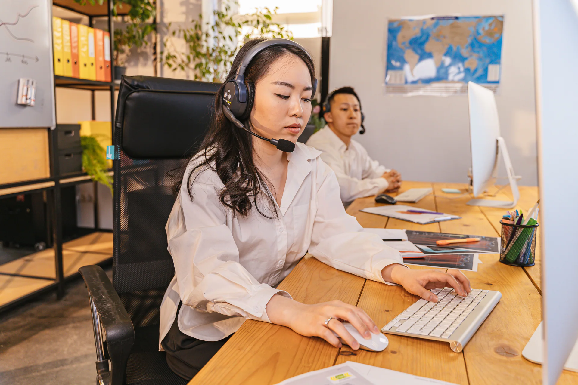 Call center agents working at computers in a bright office