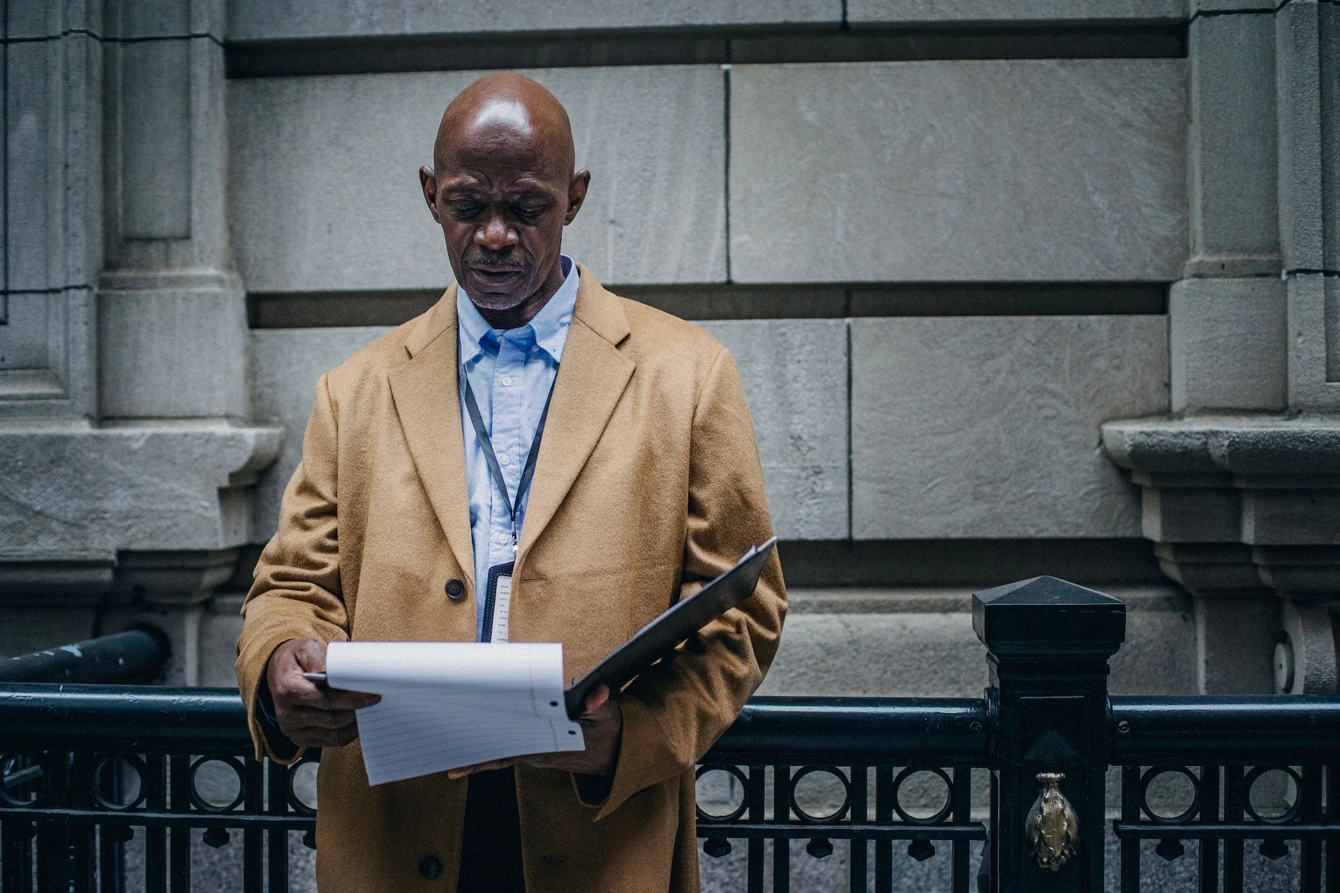 Black legal professional reviewing documents outside a courthouse