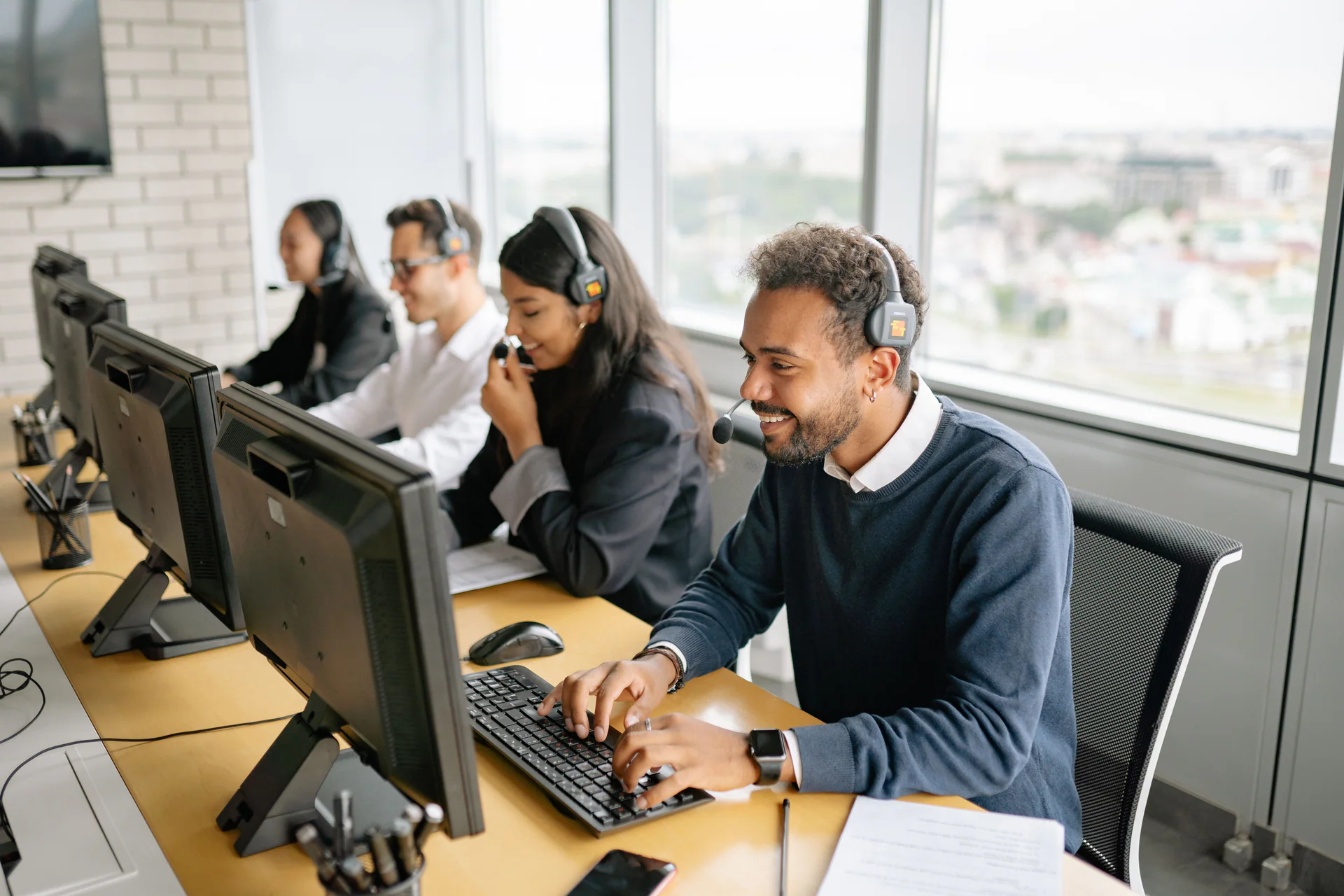 Customer support specialists handling calls at their workstations